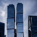 A group of tall buildings with a cloudy sky in the background.