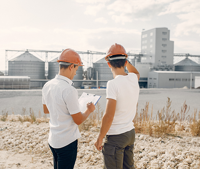 Two men in hard hats looking at a map.