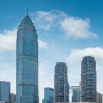A tall building with many skyscrapers in the background.