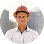 A man wearing an orange hard hat and white shirt.