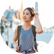 A woman with a backpack is standing outside.