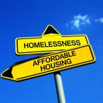 A yellow street sign that says " homelessness " and " affordable housing ".