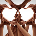 A group of hands forming the shape of a heart.