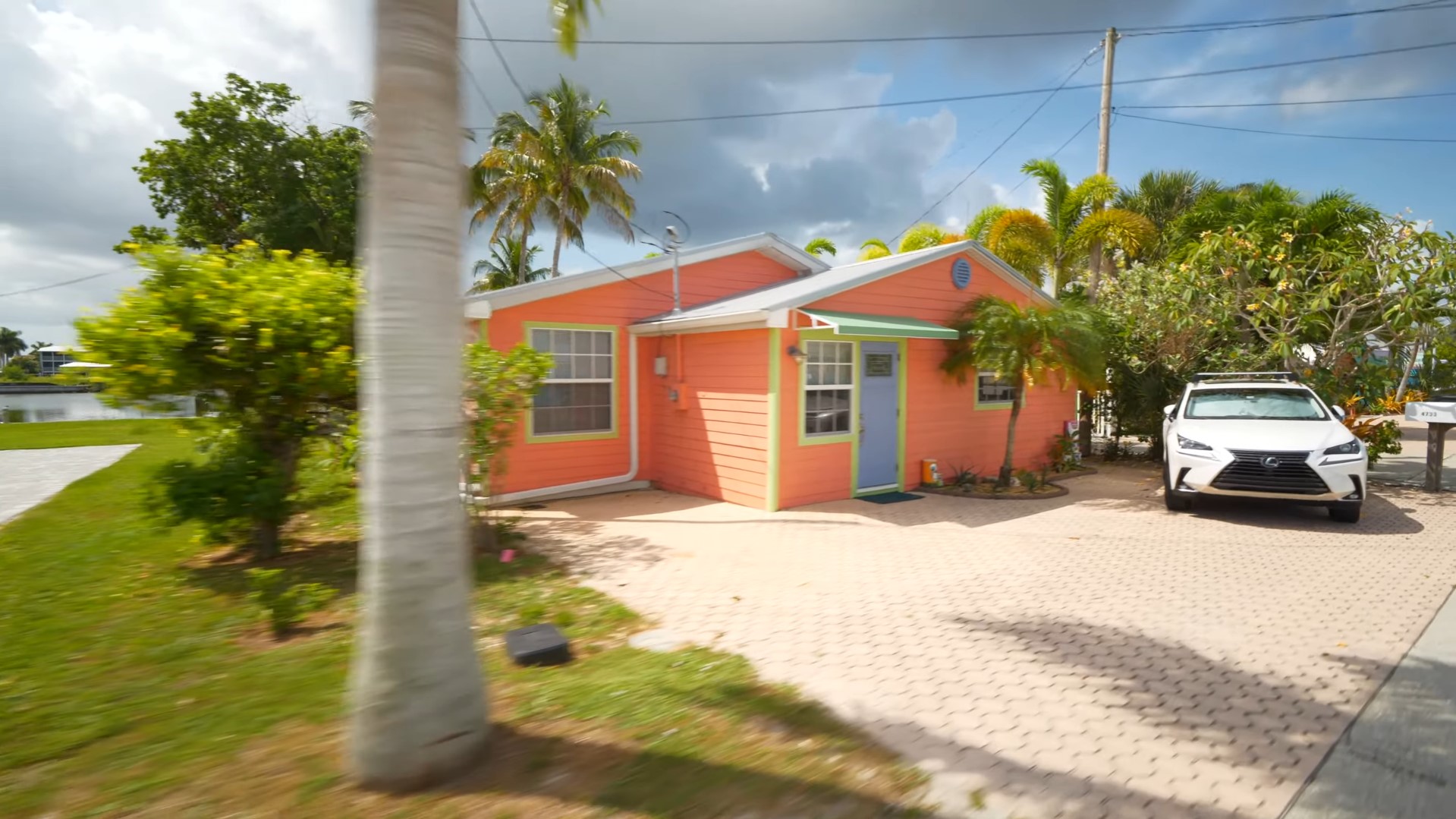 A pink house with palm trees in the background.