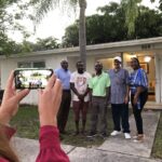 A group of people standing in front of a house.