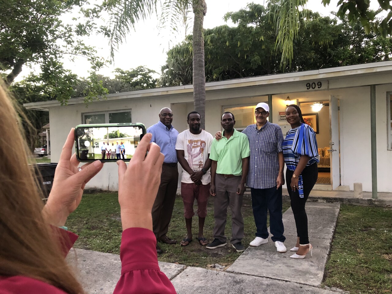 A group of people standing in front of a house.