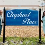 A couple standing in front of a sign.
