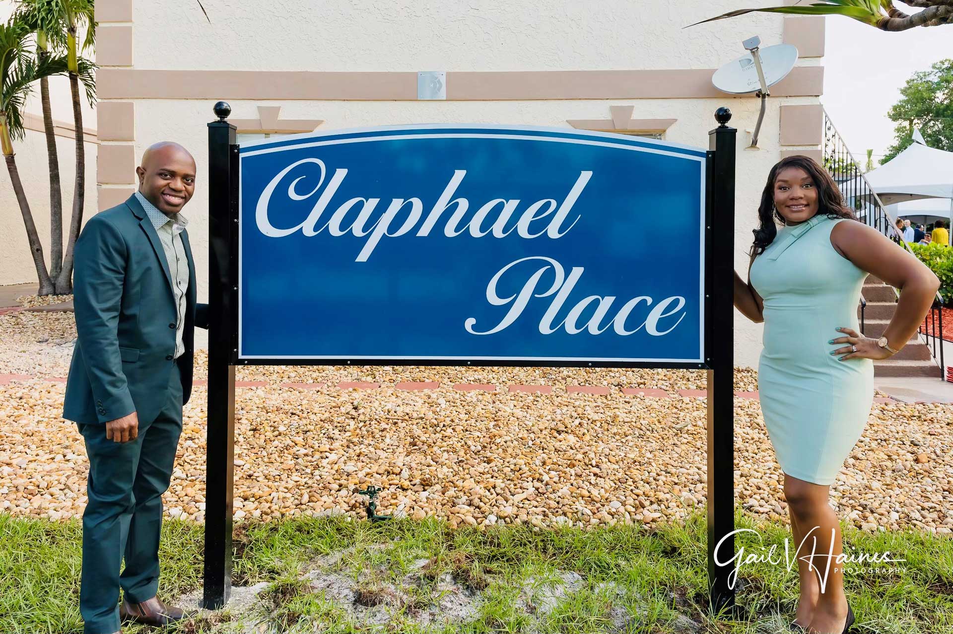 A couple standing in front of a sign.